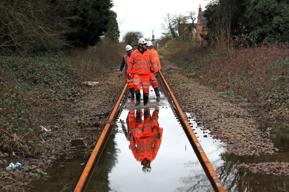 File photo dated 26/04/22 of Network Rail employees walking up the flooded line near Snaith, Yorkshire. Rail workers voting on strikes over pay were angered after a communications boss suggested they %22should have probably worked harder at school%22. Issue date: Tuesday April 26, 2022.