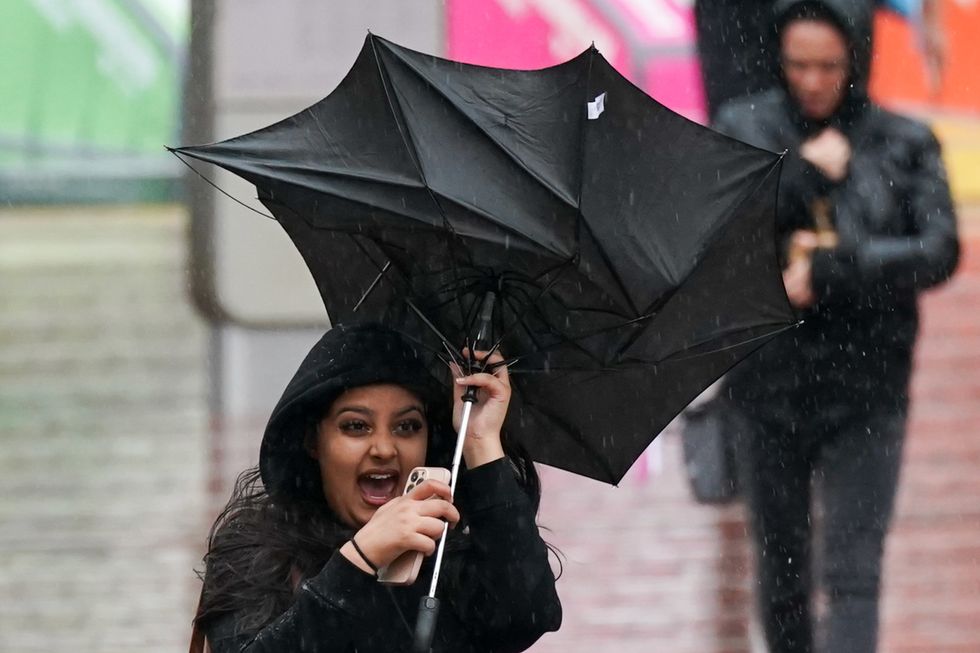File photo dated 30/09/22 of a woman struggles with her umbrella during the wet and windy weather in Birmingham. The deadly bomb cyclone that has sent temperatures plunging in the US is also causing the UK to experience wet and windy weather, the Met Office said. On Wednesday, the forecaster issued a yellow weather warning for heavy rain from 3am on Friday for 15 hours for much of Scotland, including Edinburgh, Glasgow and Stirling. Issue date: Wednesday December 28, 2022.