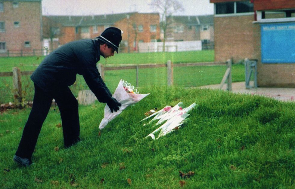 File photo dated 30/11/94 of a policeman leaving flowers at Welland County Primary School in Peterborough, the school of murdered six-year-old Rikki Neave. James Watson has been found guilty by majority verdict at the Old Bailey, London, of the murder of six-year-old Rikki who was found strangled in woodland 25 years ago, when the defendant was a boy of 13. Issue date: Thursday April 21, 2022.