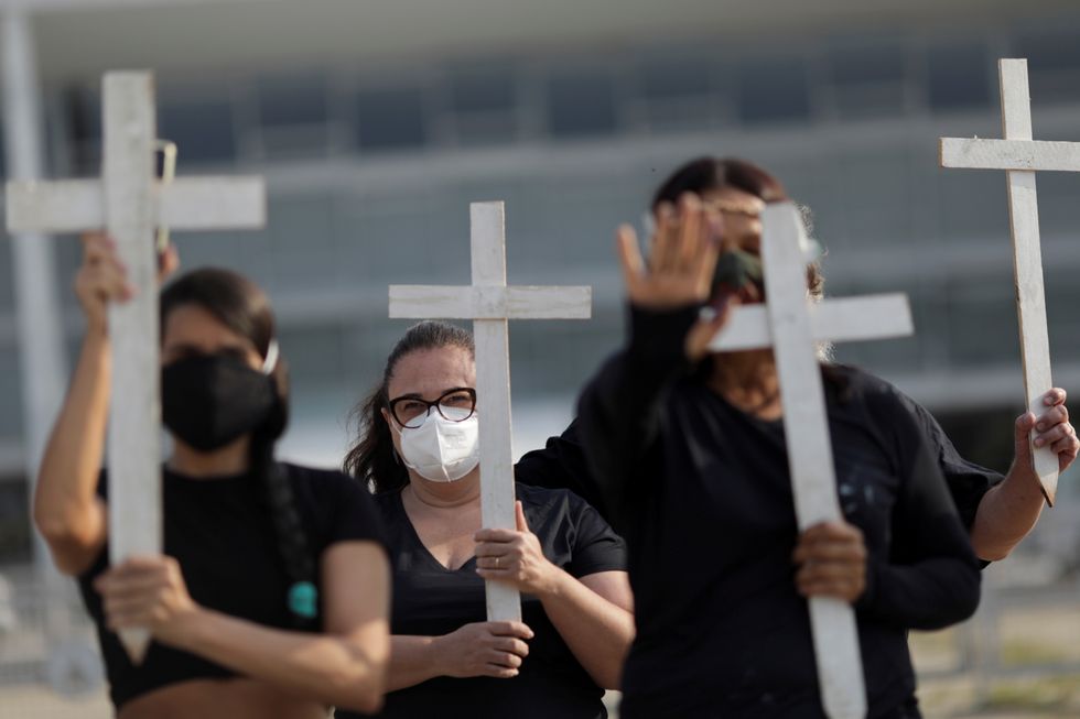 FILE PHOTO: Demonstrators hold crosses during a protest to pay tribute to Brazil's 600,000 COVID-19 deaths and against Brazil's President Jair Bolsonaro's handling of the coronavirus disease pandemic, in Brasilia, Brazil, October 8, 2021. REUTERS/Ueslei Marcelino/File Photo