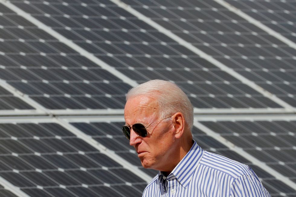 FILE PHOTO: Joe Biden walks past solar panels while touring the Plymouth Area Renewable Energy Initiative in Plymouth, New Hampshire, U.S., June 4, 2019. REUTERS/Brian Snyder/File Photo