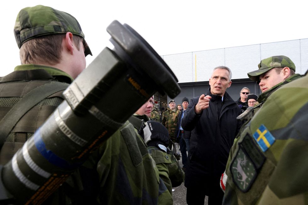 FILE PHOTO: NATO Secretary General Jens Stoltenberg gestures as he meets Swedish troops as part of a military exercise called %22Cold Response 2022%22, gathering around 30,000 troops from NATO member countries plus Finland and Sweden, amid Russia's invasion of Ukraine, at a base in Bardufoss in the Arctic Circle, Norway, March 25, 2022. REUTERS/Yves Herman/File Photo