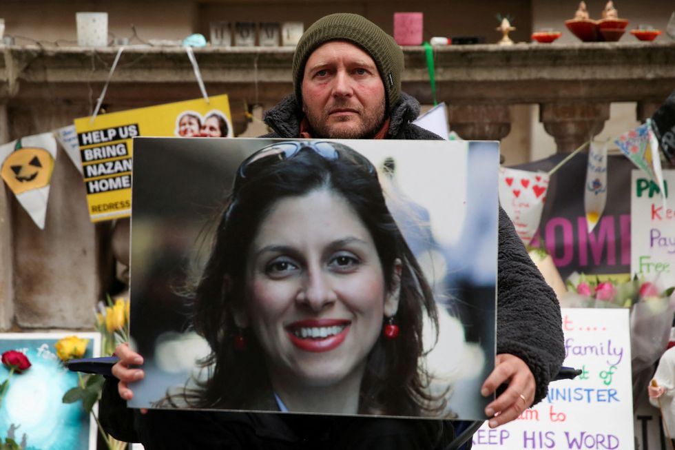 FILE PHOTO: Richard Ratcliffe, husband of British-Iranian aid worker Nazanin Zaghari-Ratcliffe, holds Nazanin's picture during the 19th day of a hunger strike outside the Foreign, Commonwealth and Development Office (FCDO), in London, Britain, November 11, 2021. REUTERS/Peter Cziborra/File Photo