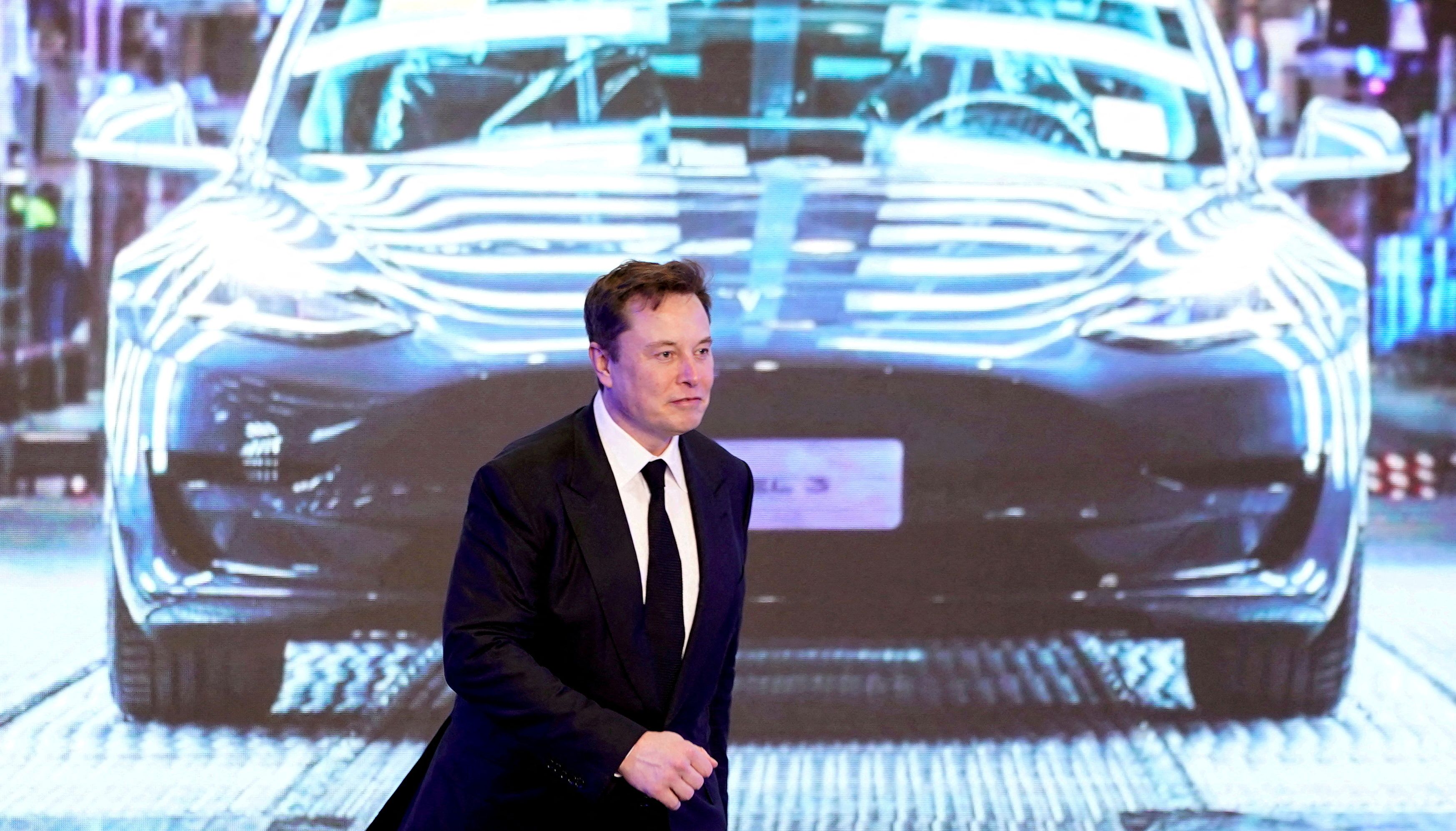FILE PHOTO: Tesla Inc CEO Elon Musk walks next to a screen showing an image of Tesla Model 3 car during an opening ceremony for Tesla China-made Model Y program in Shanghai, China January 7, 2020. REUTERS/Aly Song/File Photo