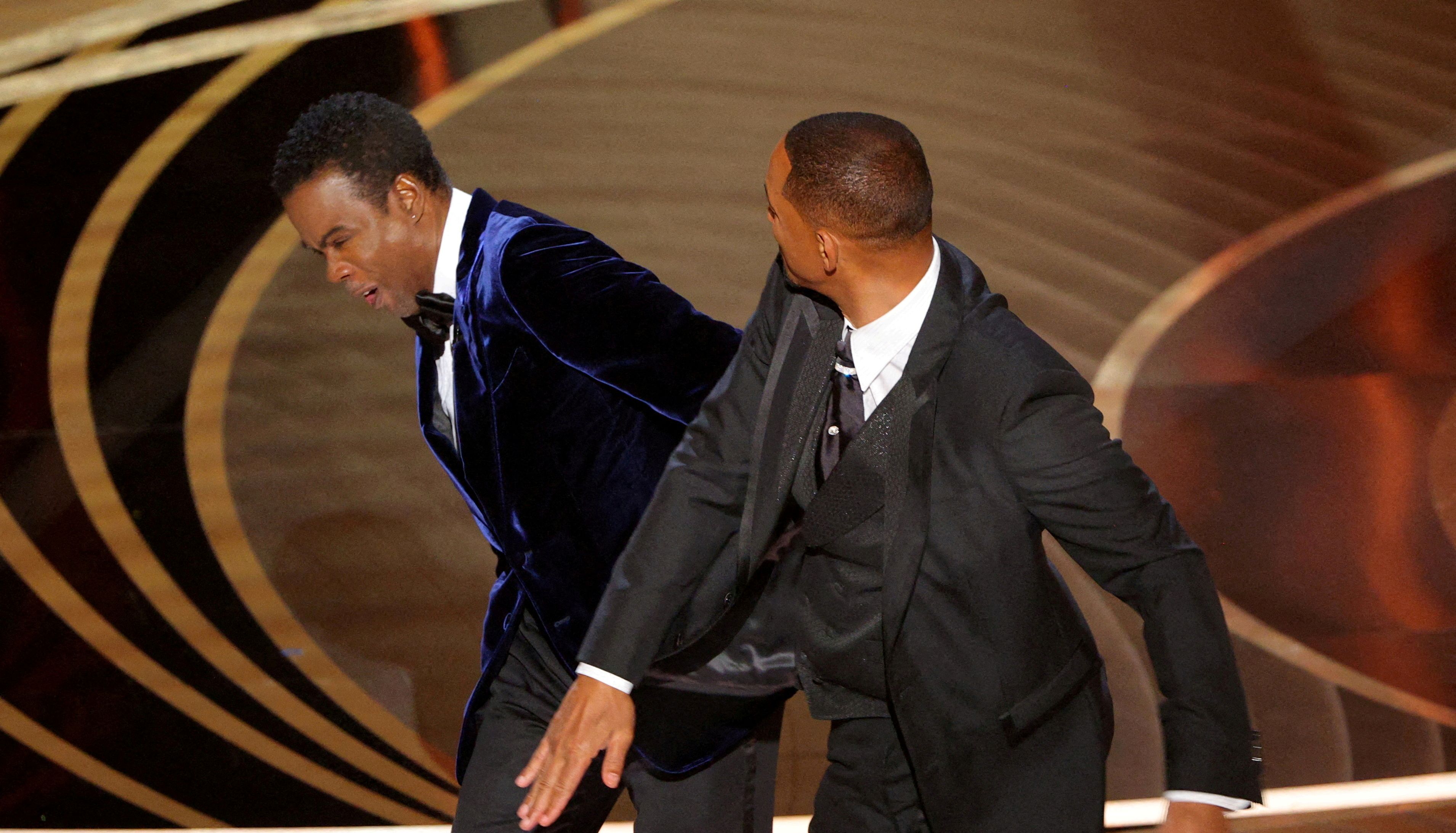 FILE PHOTO: Will Smith (R) hits Chris Rock as Rock spoke on stage during the 94th Academy Awards in Hollywood, Los Angeles, California, U.S., March 27, 2022. REUTERS/Brian Snyder/File Photo