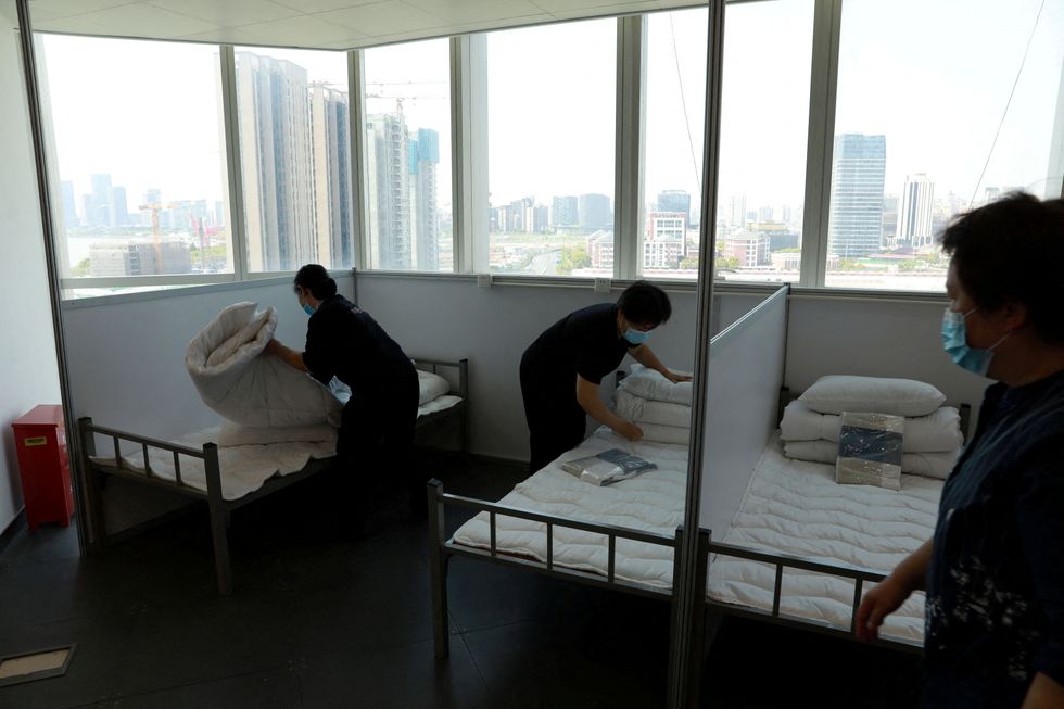 FILE PHOTO: Workers make beds at a 17-storey office building to convert it into a makeshift hospital for the coronavirus disease (COVID-19), in Shanghai, China April 12, 2022. China Daily via REUTERS ATTENTION EDITORS - THIS IMAGE WAS PROVIDED BY A THIRD PARTY. CHINA OUT./File Photo