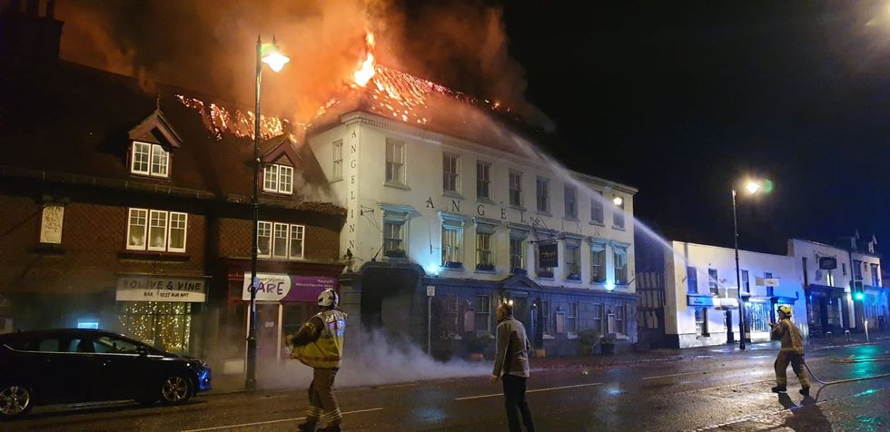 Fire fighters pouring water over hotel on fire