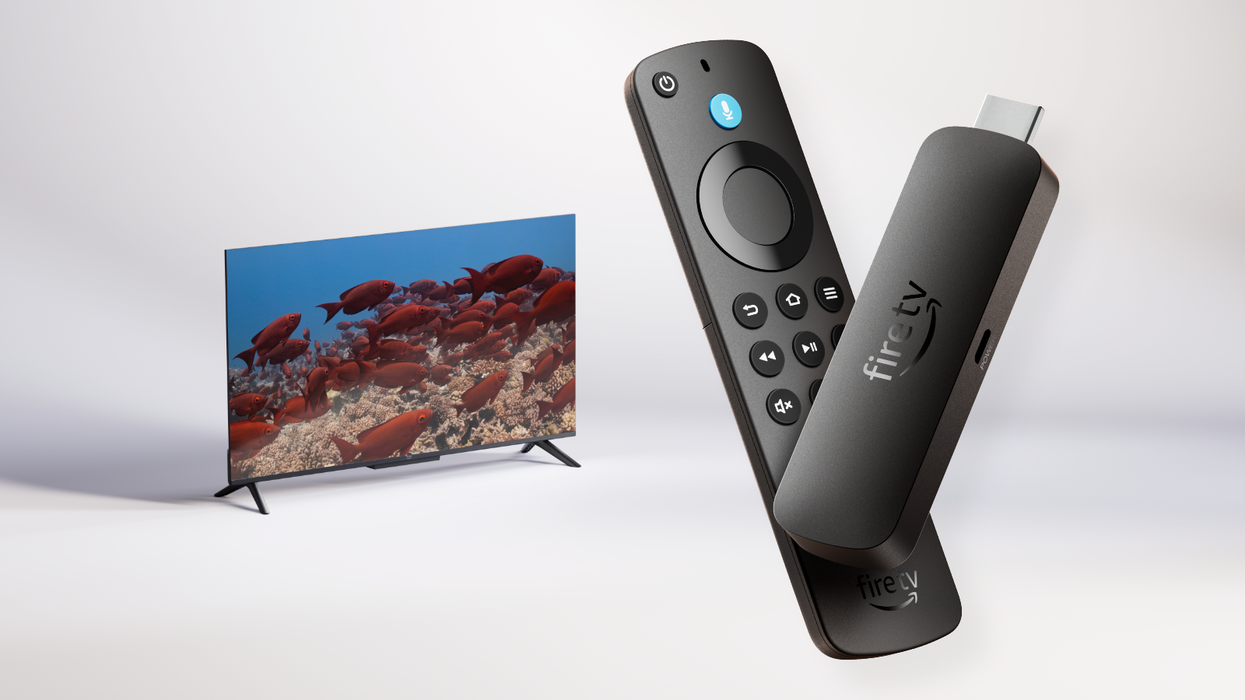 Fire TV Stick 4K Select with a television in the background