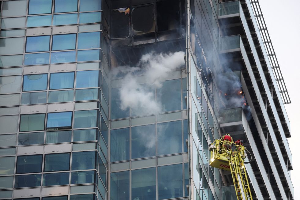 Firefighters extinguish a fire at a building in East London, Britain, March 7, 2022. REUTERS/Phil Noble