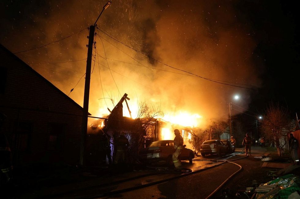 Firefighters work to extinguish a fire after air defences downed an alleged Ukrainian drone, in Kursk