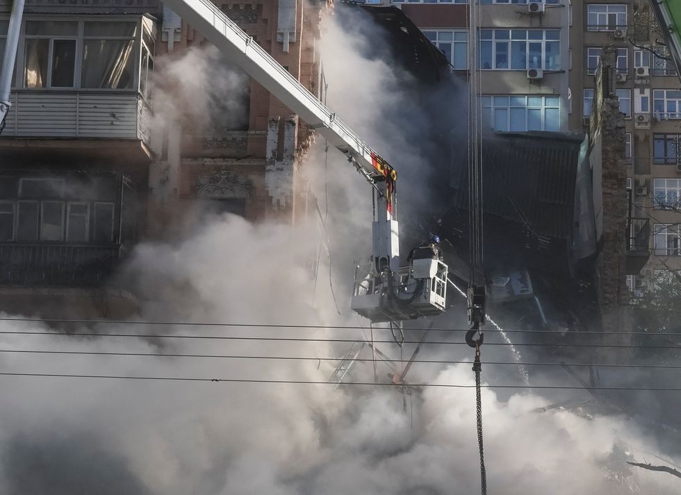 Firefighters work to put out a fire in a residential building destroyed by a Russian drones strike, which local authorities consider to be Iranian made unmanned aerial vehicles (UAVs) Shahed-136, amid Russia's attack on Ukraine, in Kyiv, Ukraine October 17, 2022. REUTERS/Gleb Garanich