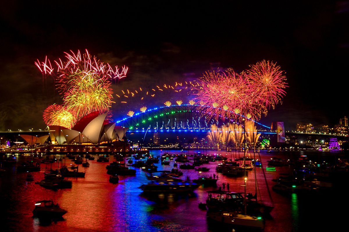 Fireworks explode over the Sydney Harbour Bridge and Sydney Opera House (L) during New Year's Eve celebrations in Sydney on January 1, 2024