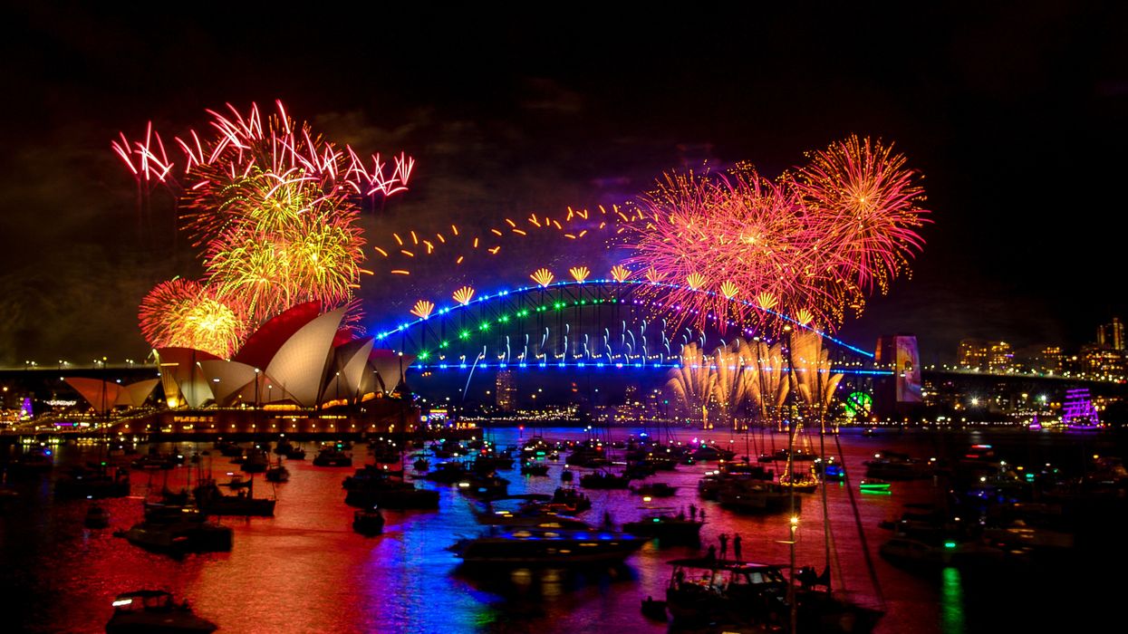 Fireworks explode over the Sydney Harbour Bridge and Sydney Opera House (L) during New Year's Eve celebrations in Sydney on January 1, 2024