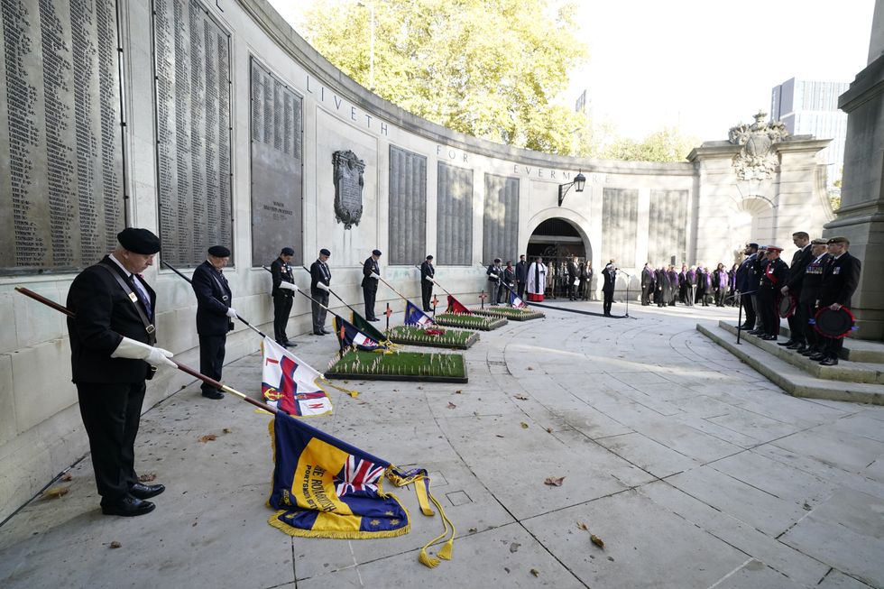 Flag bearers, veterans and members of the public observe a two minute silence an Armistice Day service