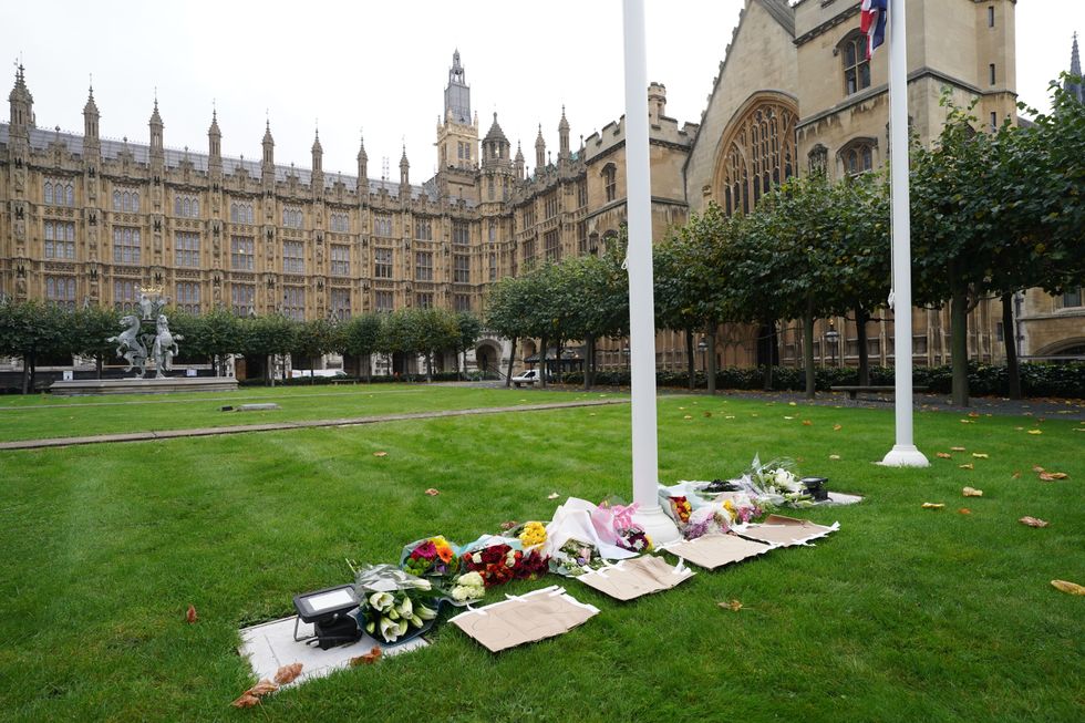 Floral tributes laid inside the gates at the Houses of Parliament in Westminster, London, following the death of Conservative MP Sir David Amess, who died after he was stabbed several times at a constituency surgery at Belfairs Methodist Church.