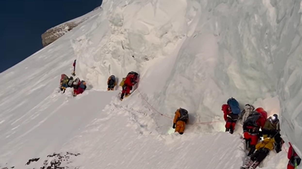 Footage shows climbers walking over the dying Sherpa, in yellow