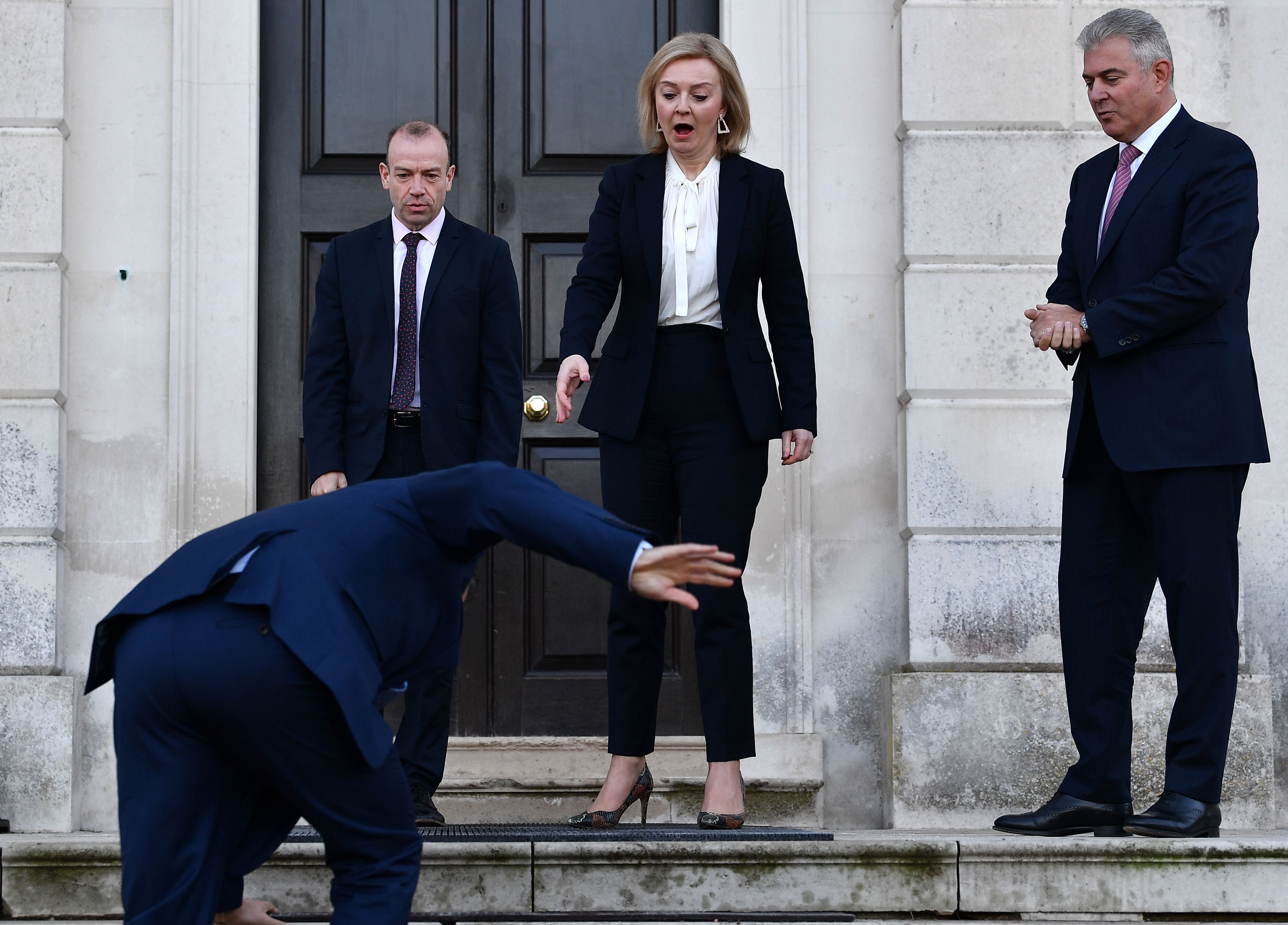 Foreign Secretary Liz Truss (centre), Minister of State for Europe Christopher Heaton-Harris (left) and Secretary of State for Northern Ireland Brandon Lewis react as EU post-Brexit negotiator Maros Sefcovic slips on an icy step upon his arrival for a meeting at Chevening in Kent.