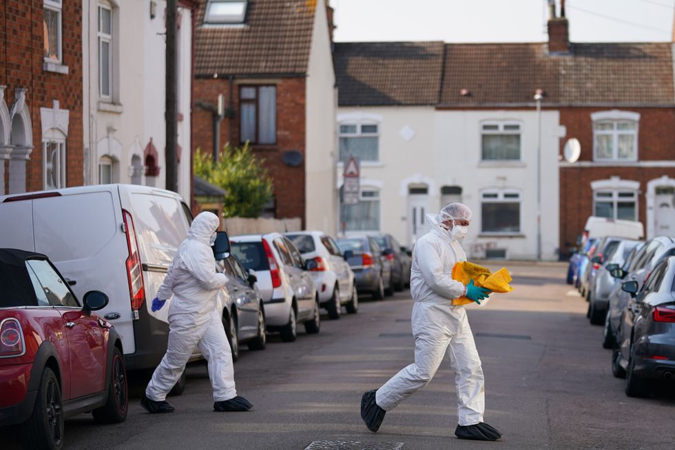 Forensic officers at the scene in Moore Street, Kingsley, Northampton following a discovery of a body in a rear garden.