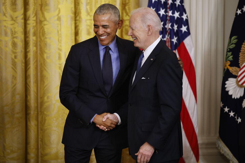 Former President Barack Obama (L) and U.S. President Joe Biden shake hands