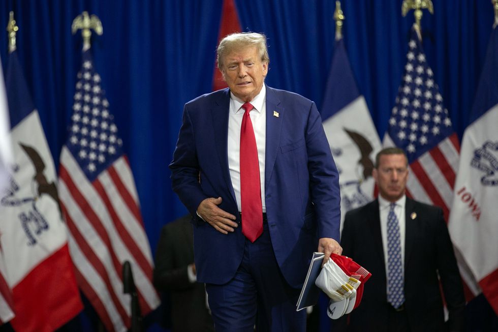 Former President Donald Trump enters from a side stage before he was set to speak to a crowd of supporters at the Fort Dodge Senior High School