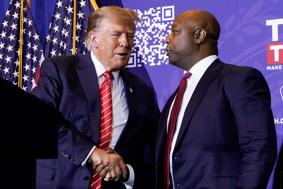 Former U.S. President and Republican presidential candidate Donald Trump greets former Republican presidential candidate U.S. Senator Tim Scott (R-SC) at a rally ahead of the New Hampshire primary election