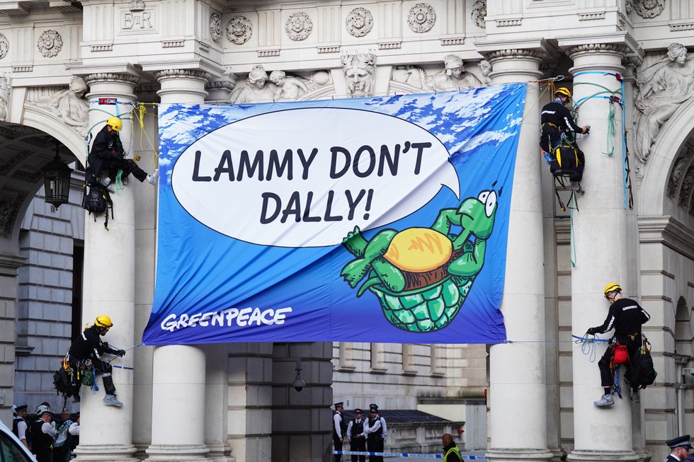 Four Greenpeace activists unfurl a banner saying "Lammy don't dally"\u200b
