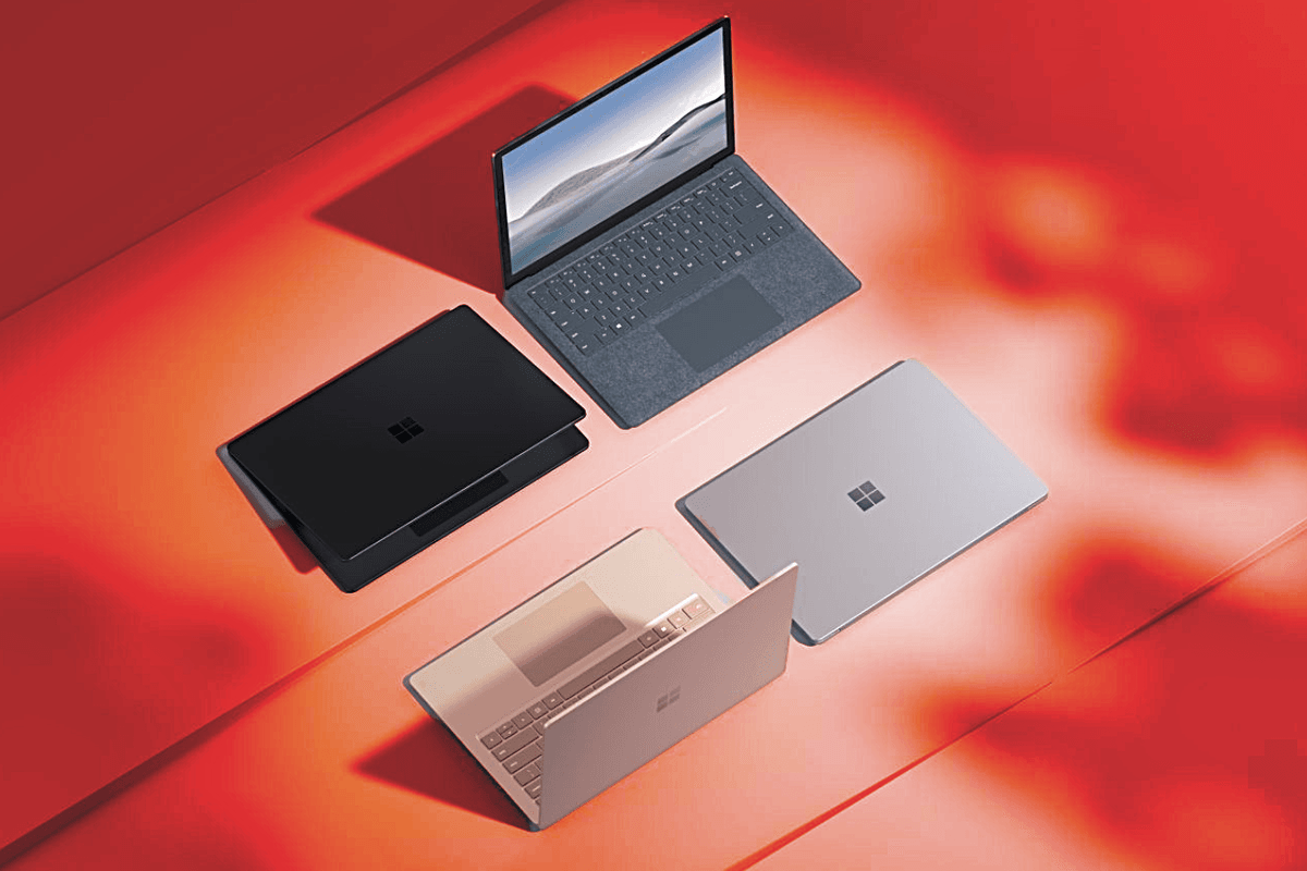 four microsoft surface laptops pictured on a surface with a red warning background