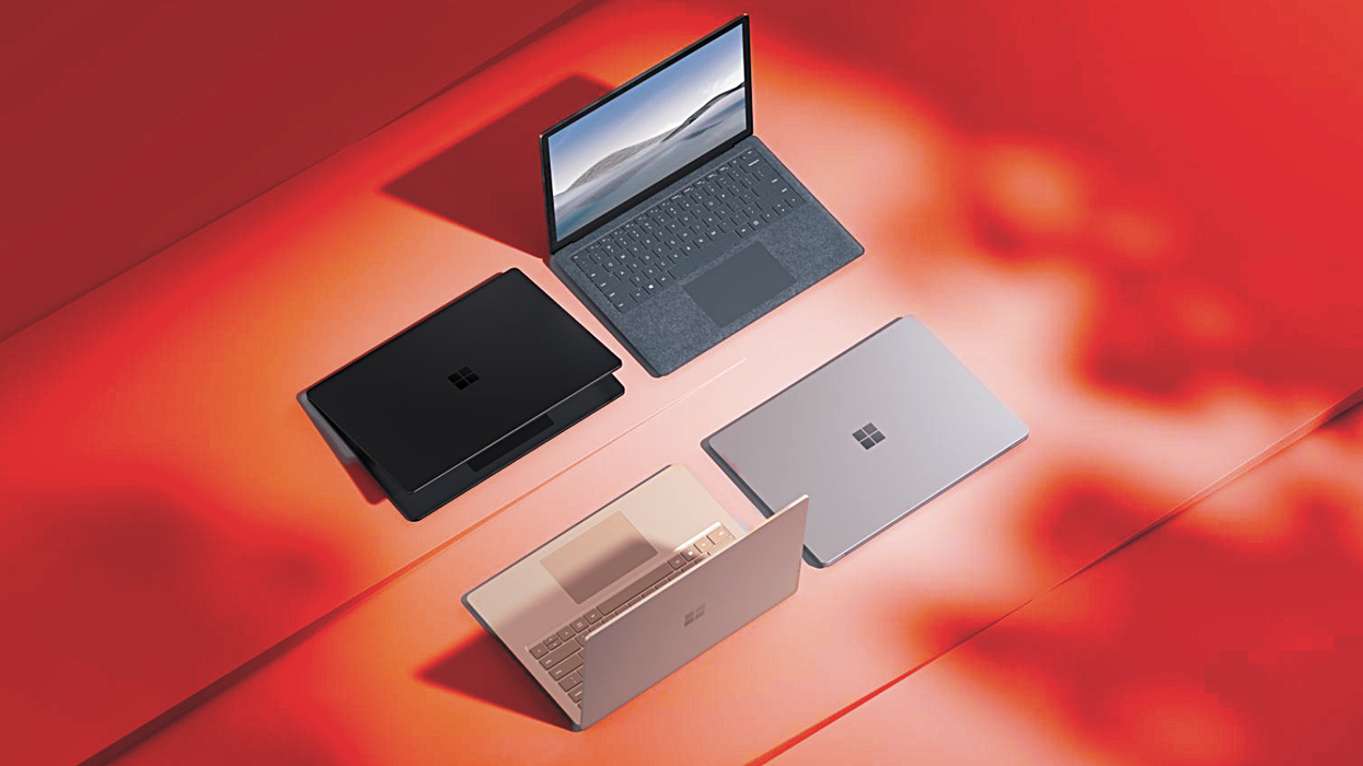 four microsoft surface laptops pictured on a surface with a red warning background