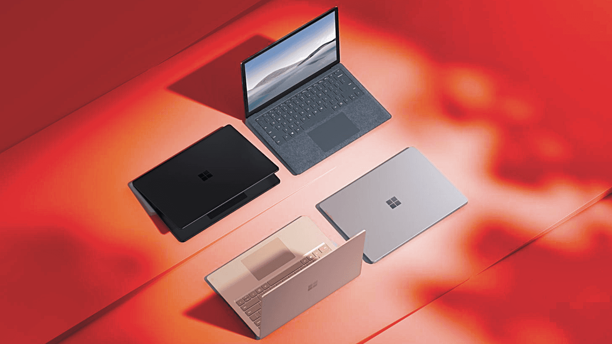 four microsoft surface laptops pictured on a surface with a red warning background