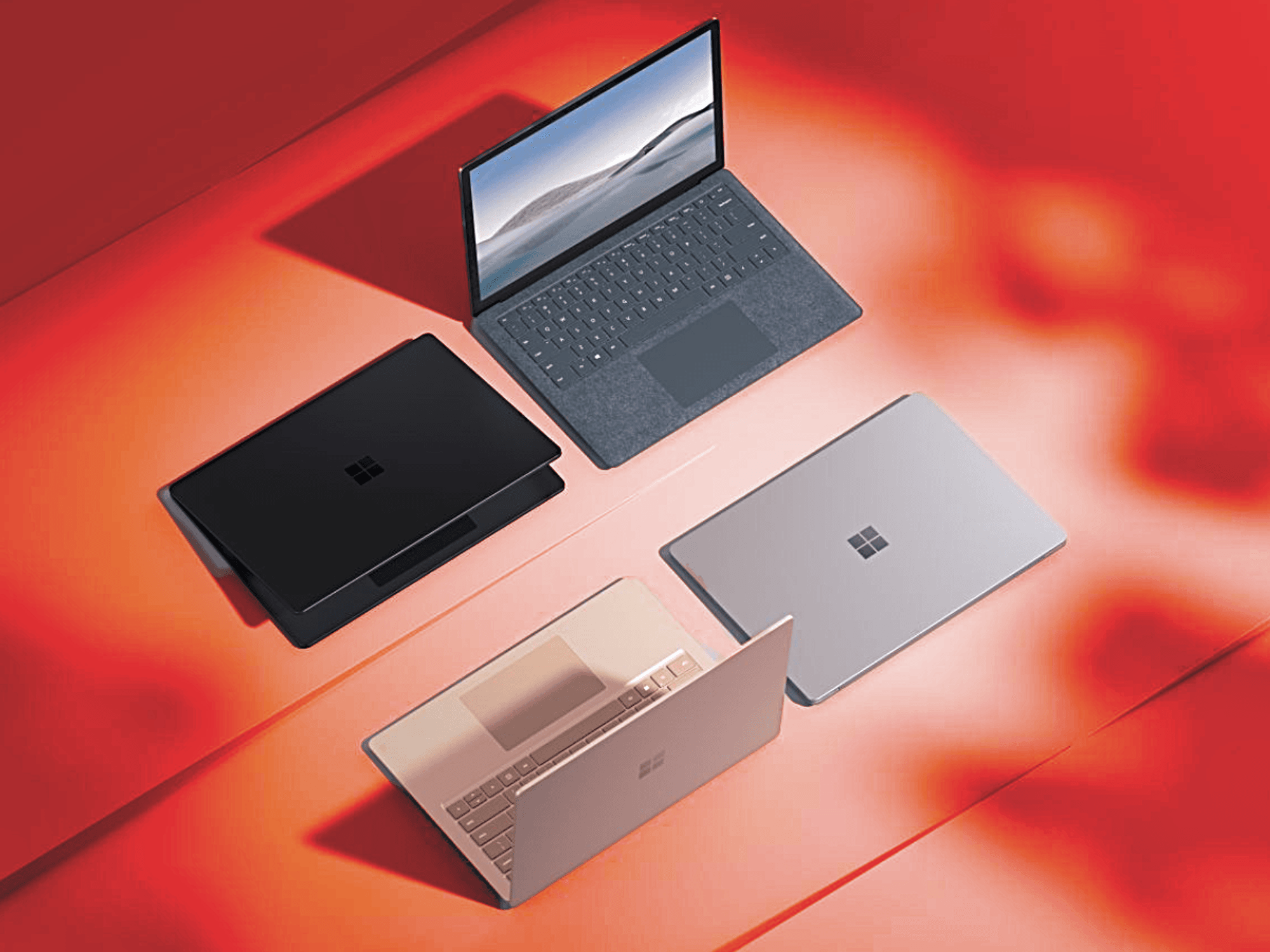four microsoft surface laptops pictured on a surface with a red warning background