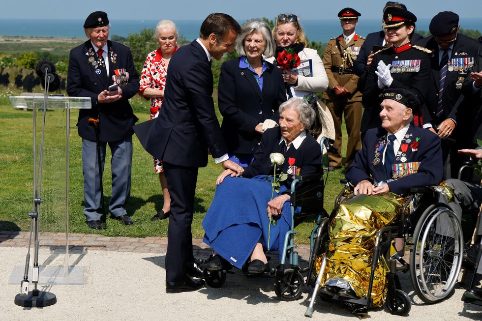 France's President Emmanuel Macron (C) reacts after awarding 104-years-old British World War II veteran, Christian Lamb (2ndR), who helped to plan the D-Day landings in Normandy