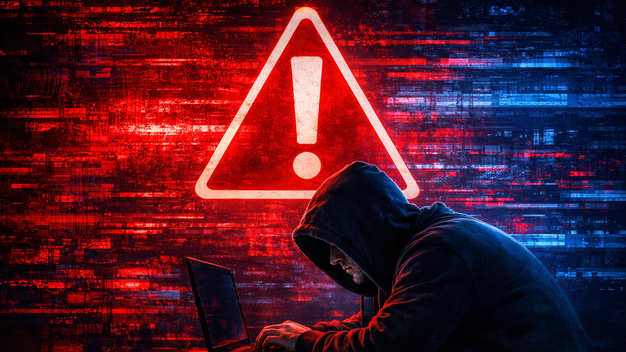 Fraudster with laptop in front of red warning sign