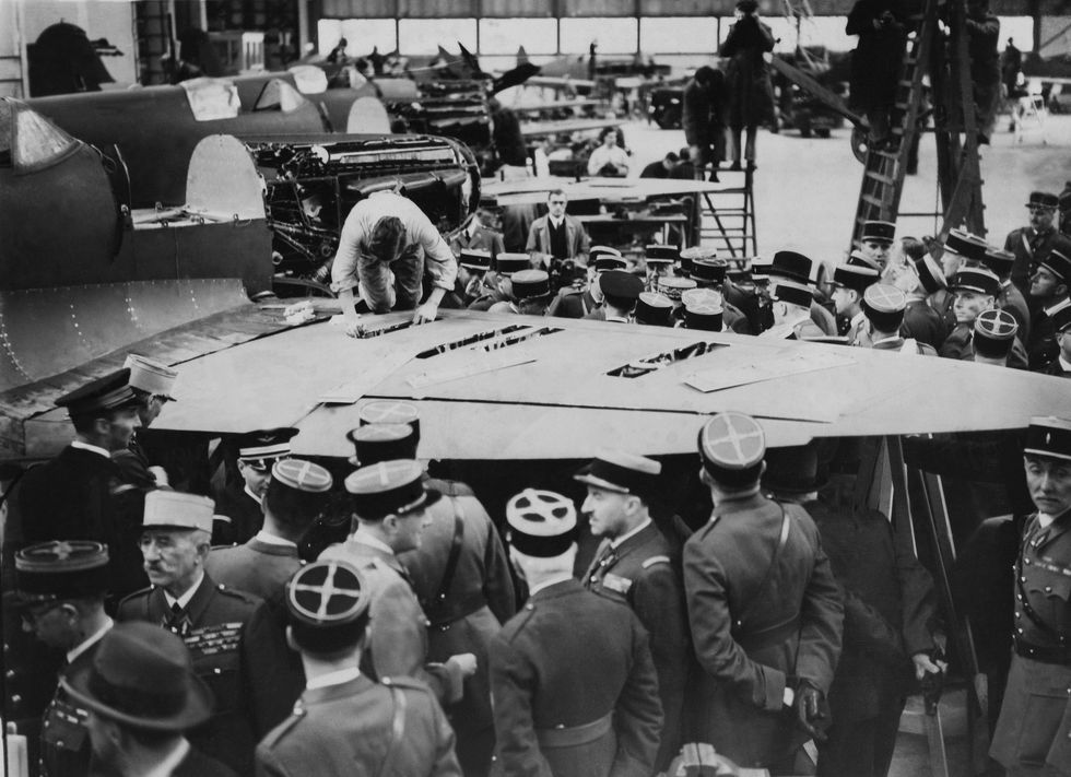 French military personnel look on as a Spitfire is built in Eastleigh