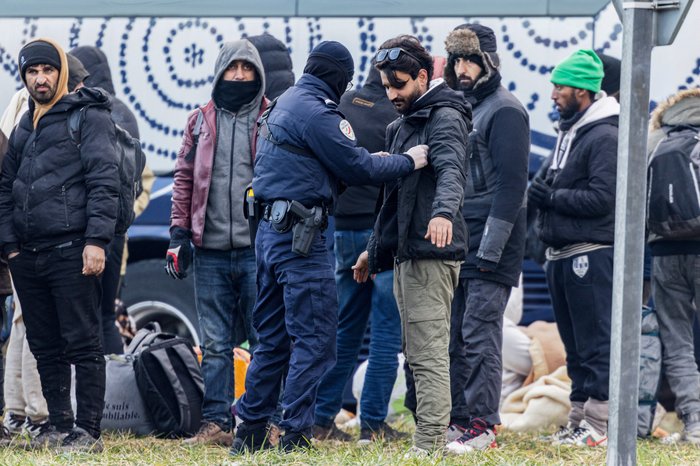 French officer searching a migrant
