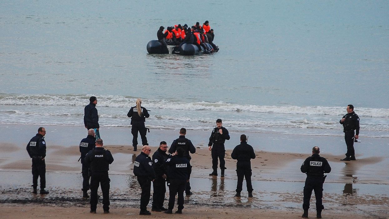 French police and small migrant boat at Calais