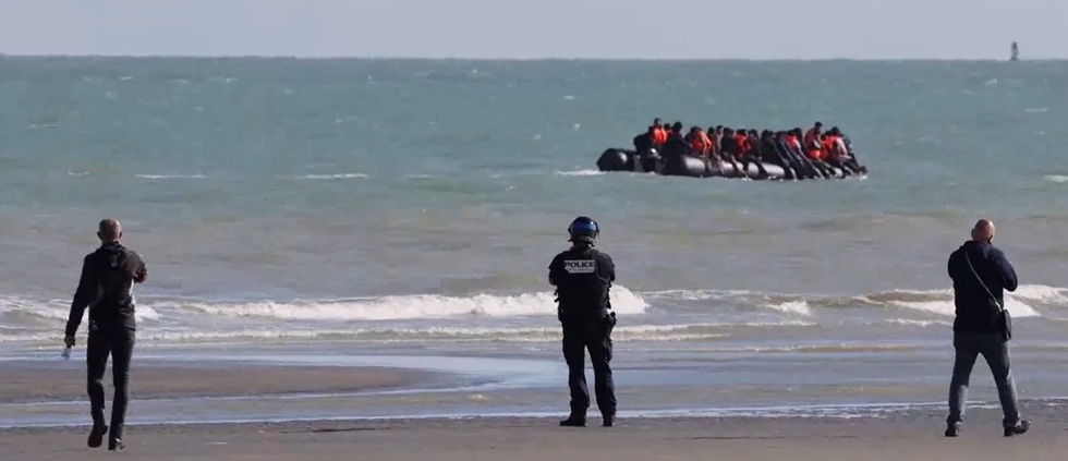 French police armed with riot shields and batons stand watch and do NOTHING as boat filled with migrants leaves for Britain