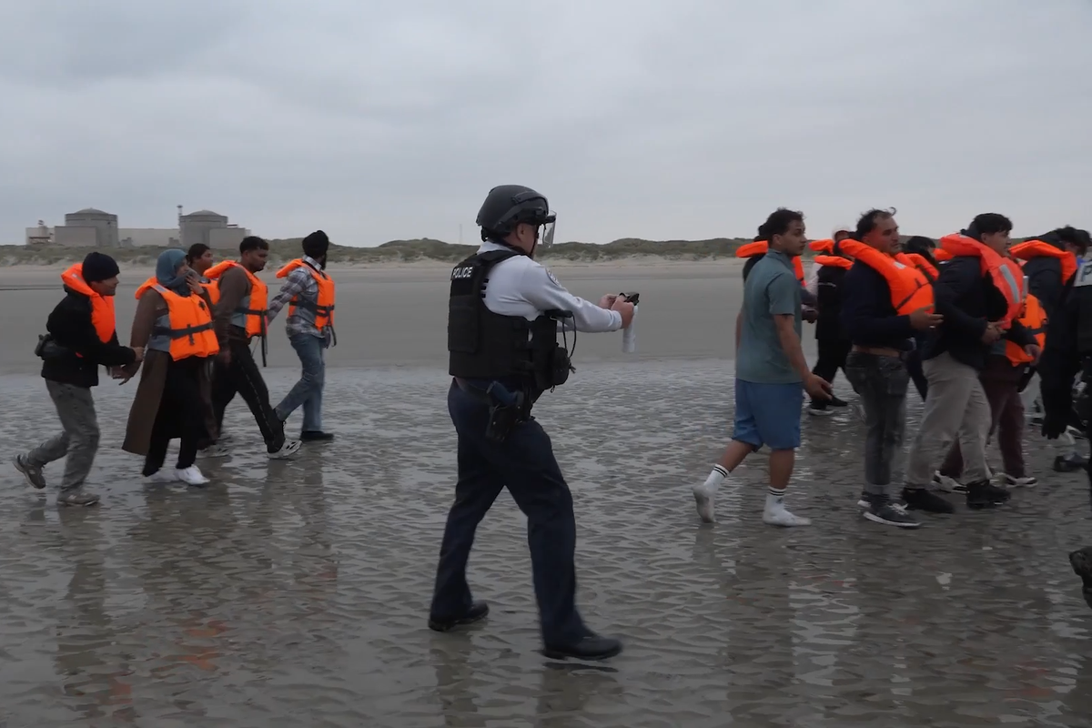 French Police pointing pepper spray at migrants attempting to cross the Channel on small boats