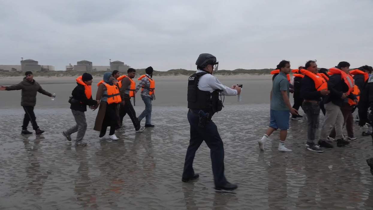 French Police pointing pepper spray at migrants attempting to cross the Channel on small boats