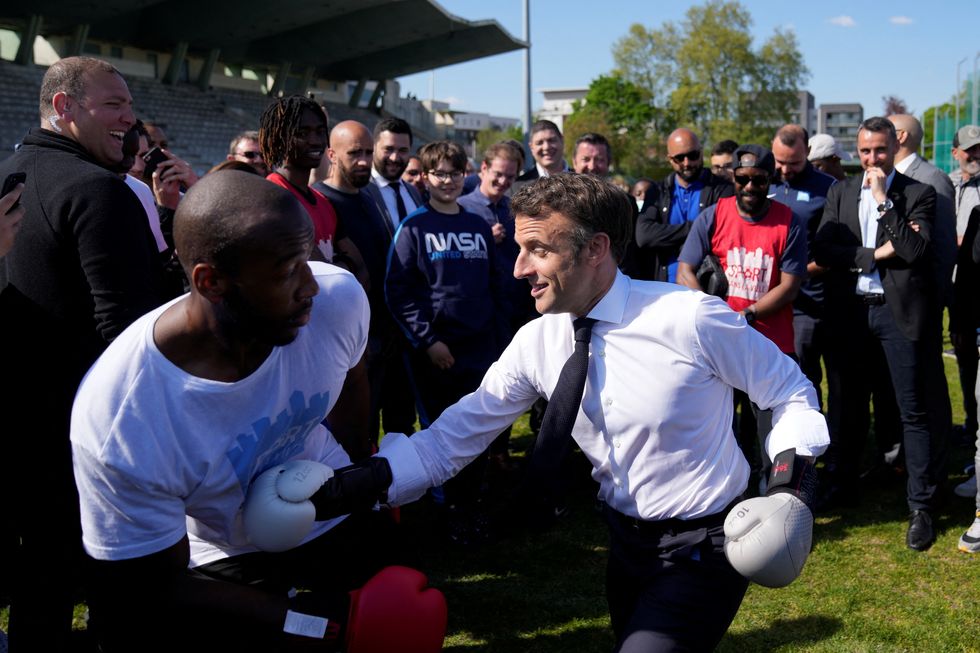 French President and La Republique en Marche (LREM) party candidate for re-election Emmanuel Macron trains with amateur boxer Jean-Denis Nzaramba in the Auguste Delaune stadium in Saint-Denis, a northern suburb of Paris, France April 21, 2022. Francois Mori/Pool via REUTERS