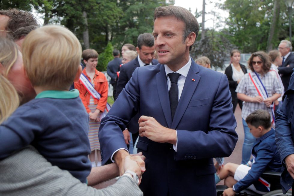 French President Emmanuel Macron cheers supporters before voting during the final round of the country's parliamentary elections, in Le Touquet.