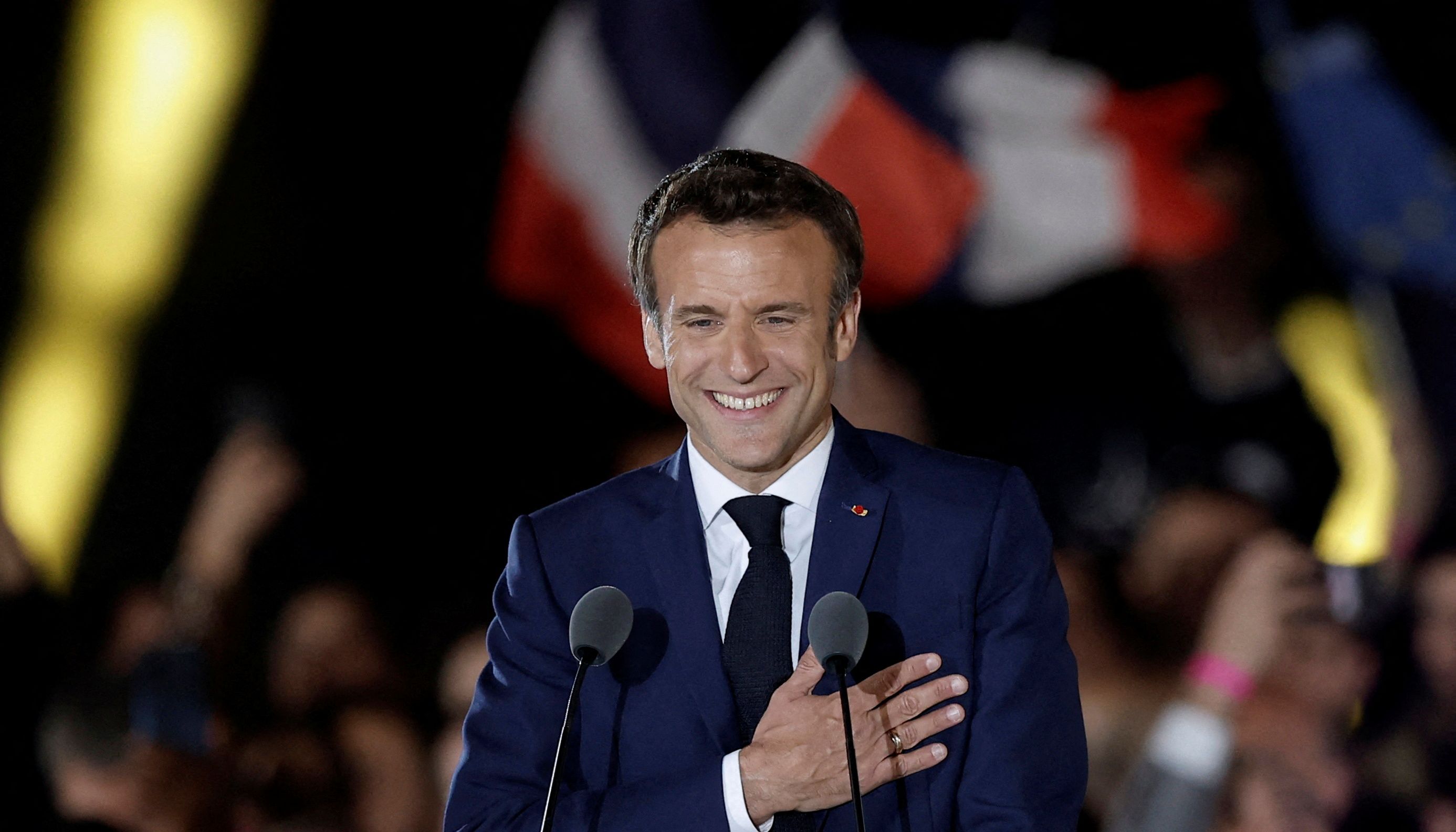 French President Emmanuel Macron gestures as he arrives to deliver a speech after being re-elected as president, following the results in the second round of the 2022 French presidential election
