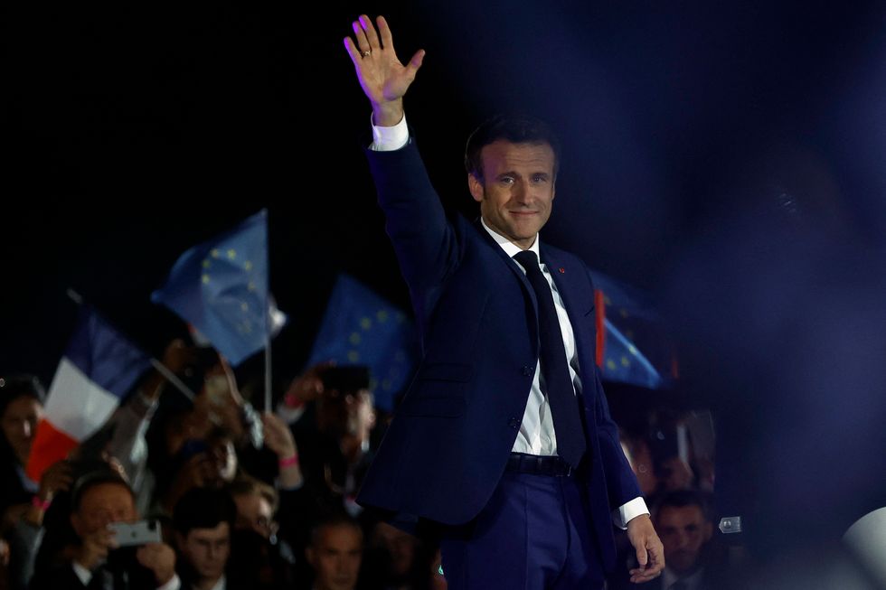 French President Emmanuel Macron waves on stage, after being re-elected as president, following the results in the second round of the 2022 French presidential election