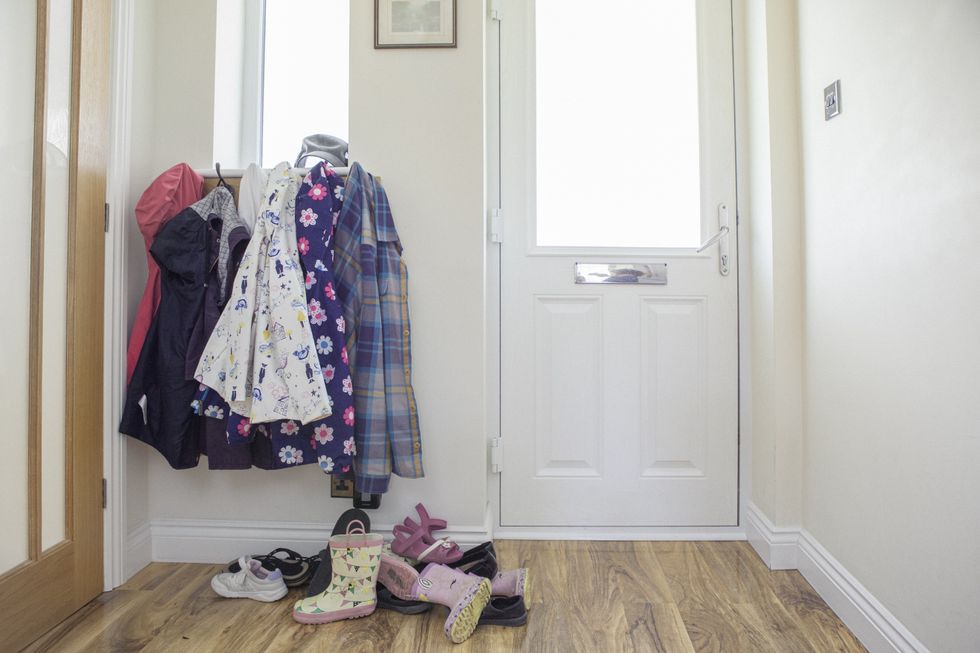 Front door with coats hung up and shoes thrown on the floor