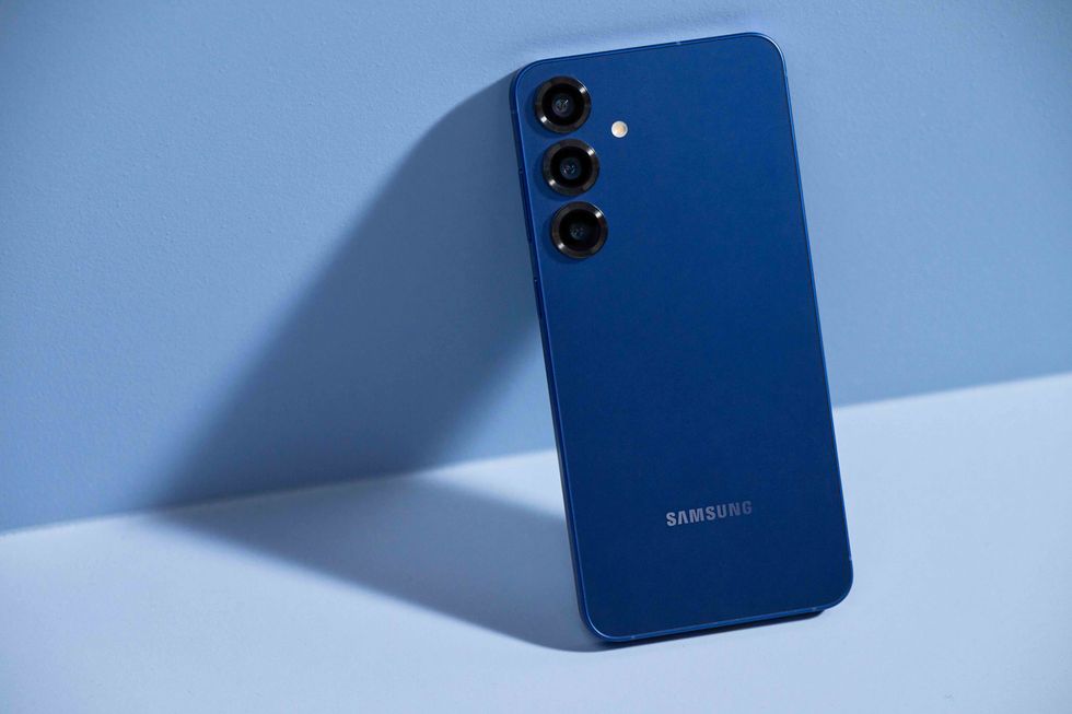Galaxy S25 phone in Navy Blue pictured leaning on its side