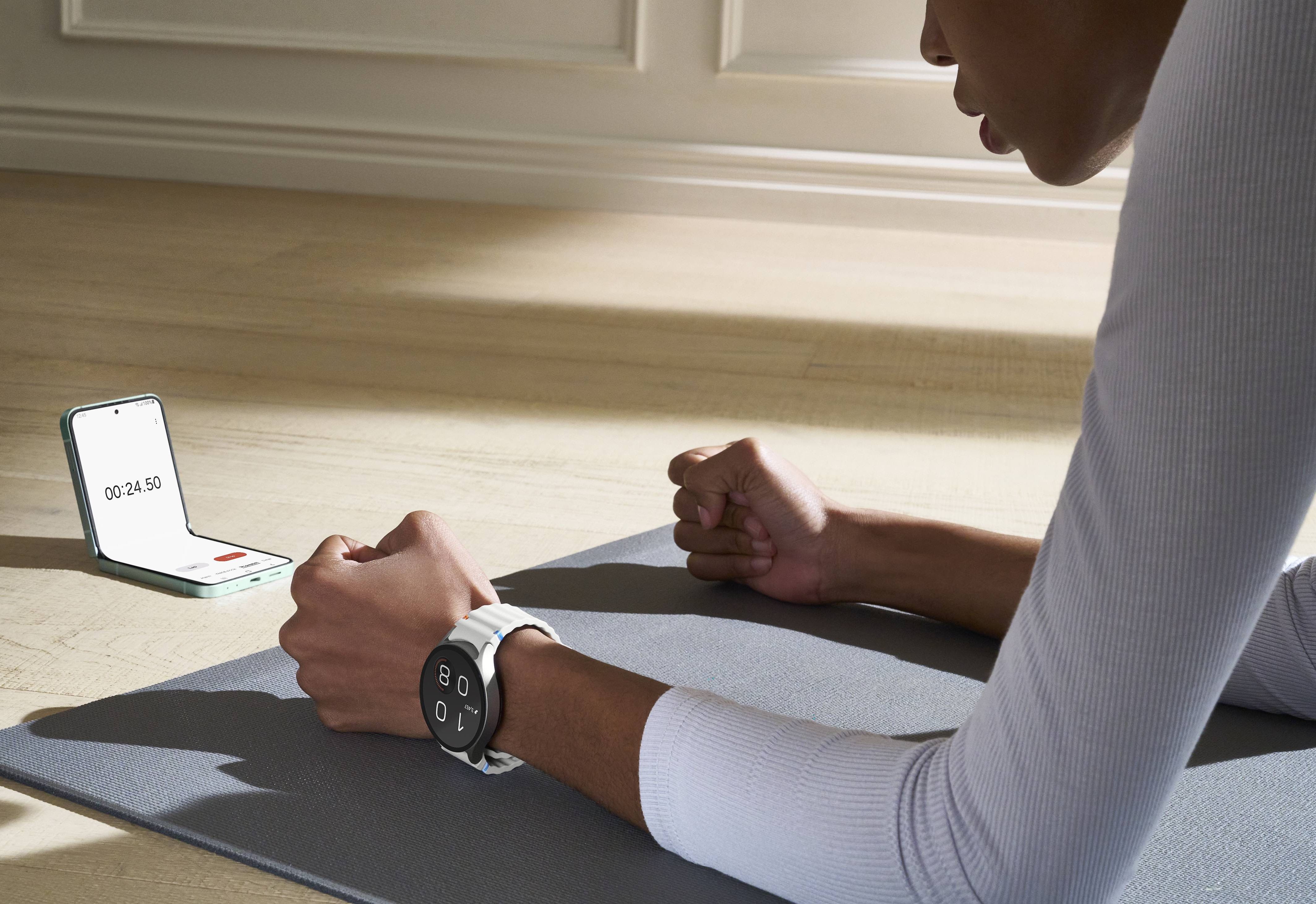 galaxy z flip 6 pictured open on the floor with a timer while someone holds a plank in the gym