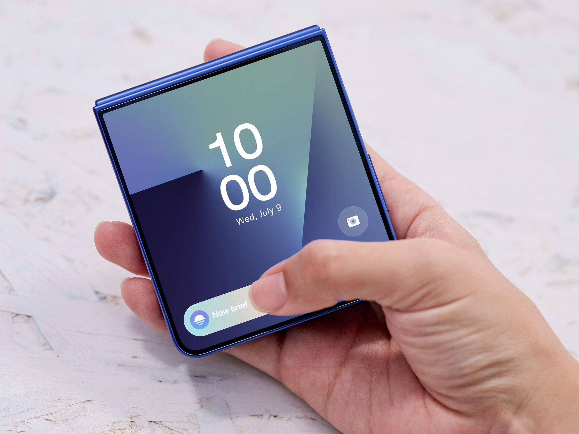 Galaxy Z Flip 7 in Blue with a hand interacting with the Now bar