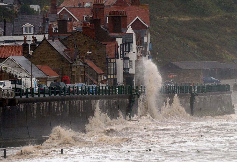 Gale force winds drive waves over the coastal road at Sandsend near Whitby