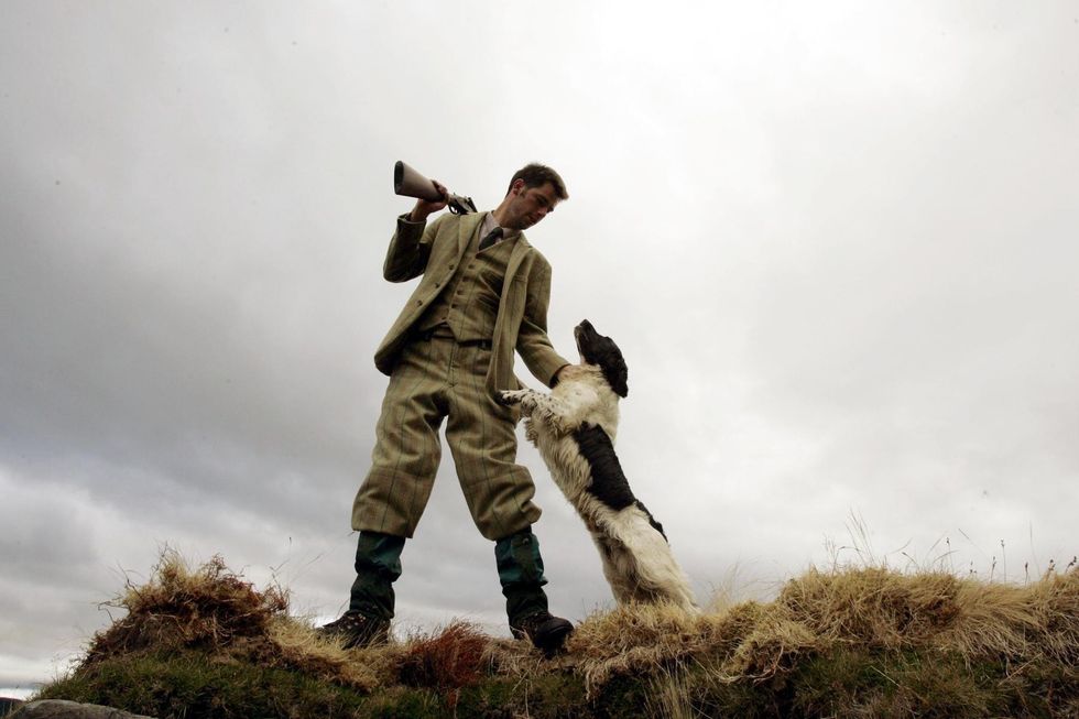 Gamekeeper Andrew Drummond from The Milton Estate with his Springer Spaniel gun dog on the Drumochter moor,