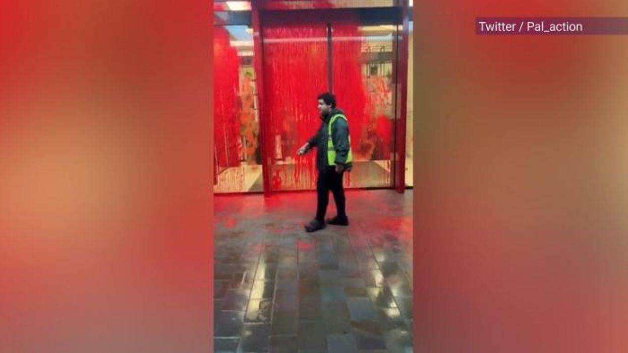 Palestine activists hurl red paint over London building and climb onto entrance roof - police on scene