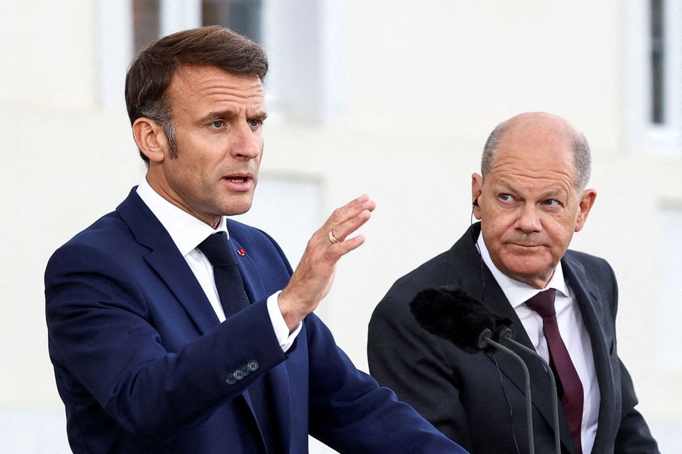 German Chancellor Olaf Scholz looks on as French President Emmanuel Macron speaks to reporters on the day of a joint Franco-German cabinet meeting